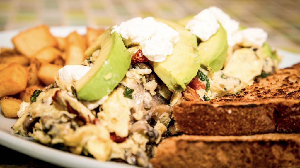 The Favorite · 3 eggs scrambled with goat cheese, sun-dried tomatoes, avocado, mushrooms and basil. Served with breakfast potatoes and toast.
