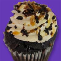 Turtle Cupcake · Decadent chocolate cake adorned with pecans, walnuts, caramel and chocolate drizzle.