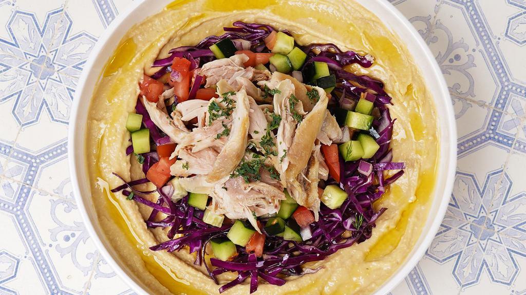 Roasted Chicken Hummus Bowl · Original hummus drizzled in olive oil and spices served with roasted chicken, cabbage, cucumber tomato salad, tahini, and a side of pita bread.