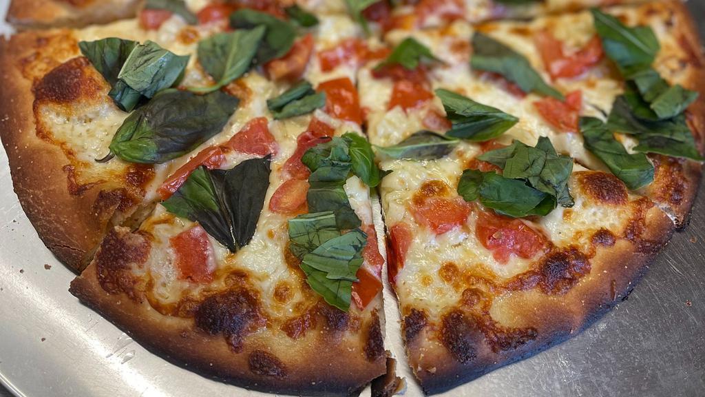 Margherita Pizza · Fresh homemade dough and extra virgin olive oil topped with our organic mozzarella cheese, fresh tomatoes and garlic, and showered with fresh basil