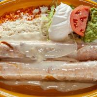 Flautas · Two flautas, one with chicken and one with shredded beef, served over a bed of Spanish rice,...