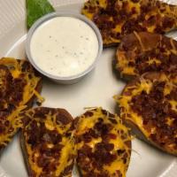 Potato Skins · Six potato wedges topped with melted cheese and bacon bits.  Served with sour cream.