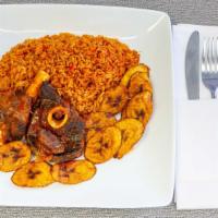 Jollof Rice W/ Fish Or Goat · Served with plantain and red stew with fish or goat.