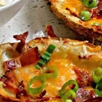 Potato Skins · Five skins loaded with Cheddar bacon and chives with a side of sour cream.