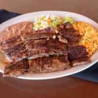 Carne Asada · a juicy beef steak, served with Spanish rice & refried beans.