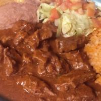 Carne Guisada Plate · Seasoned Beef Tips sautéed in a flavor tomato sauce served with spanish rice & refried beans.