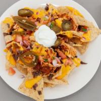 Nachos · Tortilla chips, choice of meat, nacho cheese sauce, beans, pico de gallo, jalapeno, sour cream