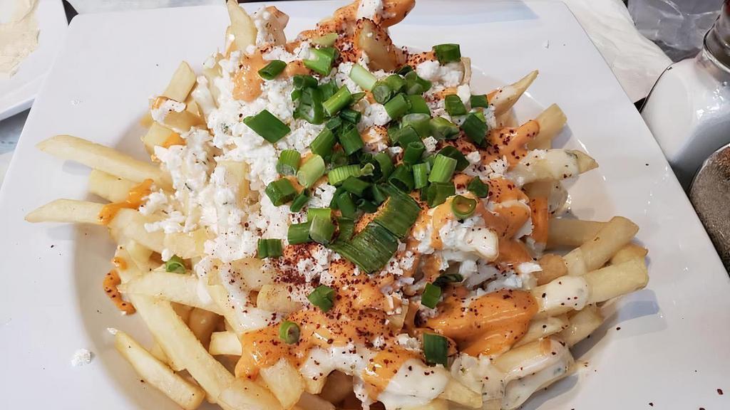Greek Fries · Topped with crumbled feta cheese, green onion, sumac, drizzled with garlic mayo, and hot sauce.