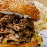 Kalua Pig Sandwich · Kalua Pig & Cabbage with Mayo on Toasted Potato Bun. Served with Choice of Mac Salad or Gree...