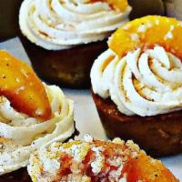 Peach Cobbler Cupcakes · Moist vanilla cupcake stuffed with real peaches and a peach cobbler filling, topped with cre...