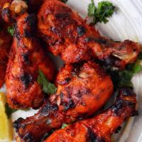 Tandoori Chicken With Spinach Rice · Bone-in chicken legs marinated in spices yogurt and cooked in tandoor oven And SERVED OVER S...