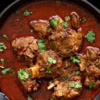 Goat Curry · Bone-in goat meat cooked with coriander onion tomato sauce.