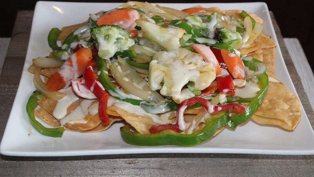 Nachos Vegetarianos · Grilled bell peppers, onions, tomatoes, cauliflower, carrots, and broccoli. Served on a bed of crispy tortilla chips.