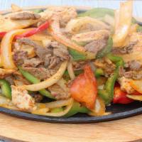 Chicken And Steak Fajitas · Served with onions, bell peppers, beans, and rice: garnished with lettuce, pico de gallo, so...