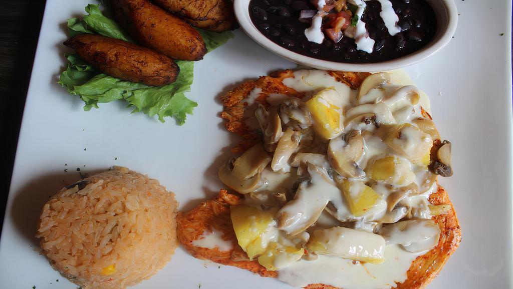 Pollo Tropical · Ten ounce juicy chicken breast grilled to perfection, topped with chunks of pineapple, mushrooms, and cheese sauce. Served with rice, black beans and sweet plantains.