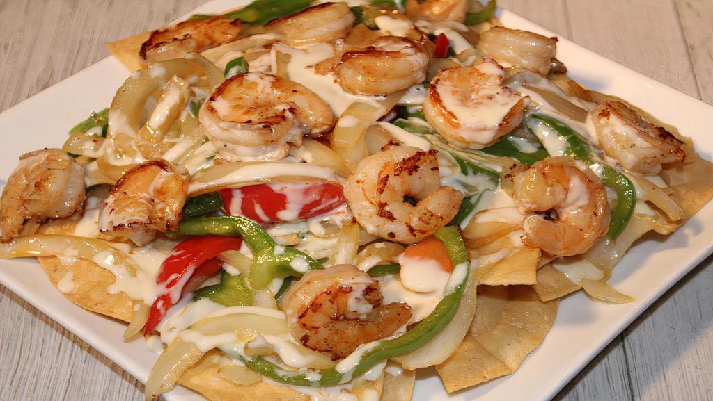 Shrimp Fajita Nachos · A bed of crispy nachos topped with grilled shrimp, bell peppers, onions, tomatoes, lettuce, and sour cream.