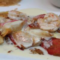 Pescado Al Horno · Grilled tilapia white fish with sautéed shrimp and imitation crabmeat, topped with garlic sa...