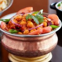 Chana Masala · While chickpeas stewed with tomato, ginger, garlic and turmeric.