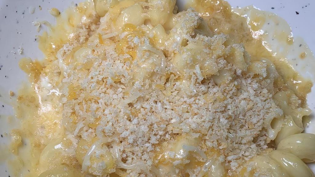 Mac-N-Cheese · Our house cheese sauce tossed with double elbow pasta and finished with a ritz cracker topping.