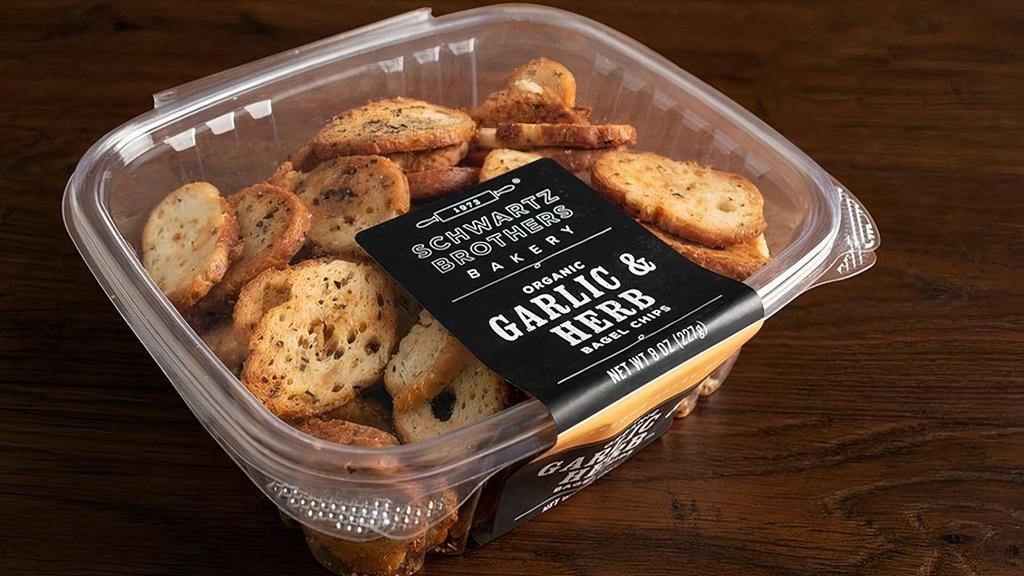 Bagel Chips - Garlic & Herb · Bagel Chips - Garlic & Herb.  Mixed in small batches and twice baked to achieve just the perfect crispy crunch.  Made with organic olive oil, organic garlic and organic seeds blend.  8 oz pack.  Kosher Parve, Vegan