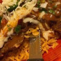 El Macho · Spanish rice topped with melted cheeses, a rib-eye steak, one cheese enchilada and pico de g...