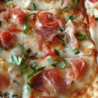 Prosciutto Flat Bread · Roasted tomatoes, garlic and basil over mozzarella cheese with prosciutto ham and finished w...