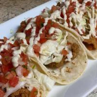 Fish Tacos · Beer battered tilapia, seasoned and fried served in corn tortillas topped with green cabbage...