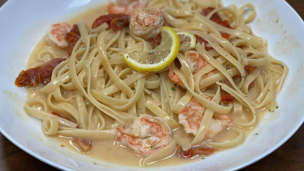 Shrimp Scampi · Shrimp sauteed in garlic, white wine in a light cream lemon-butter sauce with sundried tomatoes, served over fettuccine.