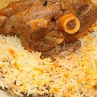 Quzi Lamb · Cooked lamb shank, served on rice with soup and sauces.