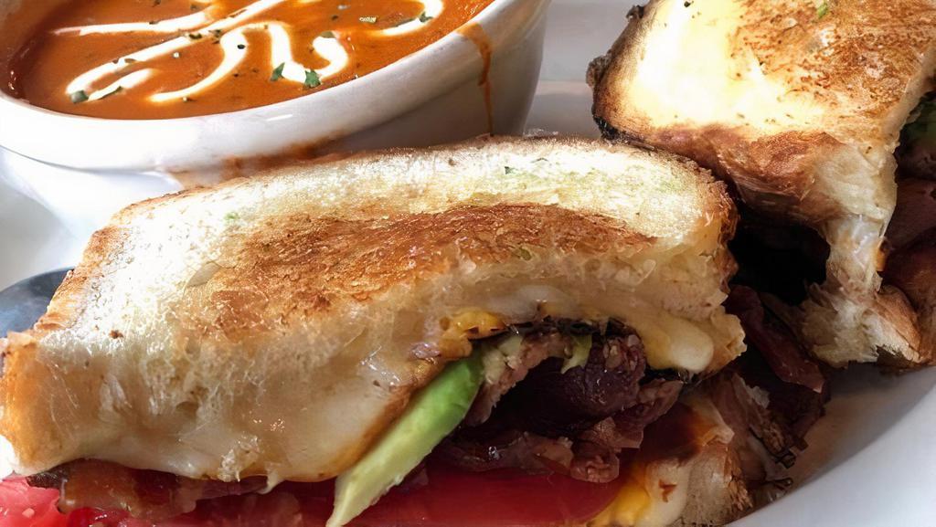 Triple Grilled Cheese · Cheddar, American and Swiss cheeses with Applewood smoked bacon, tomato and avocado grilled between sliced sourdough bread.