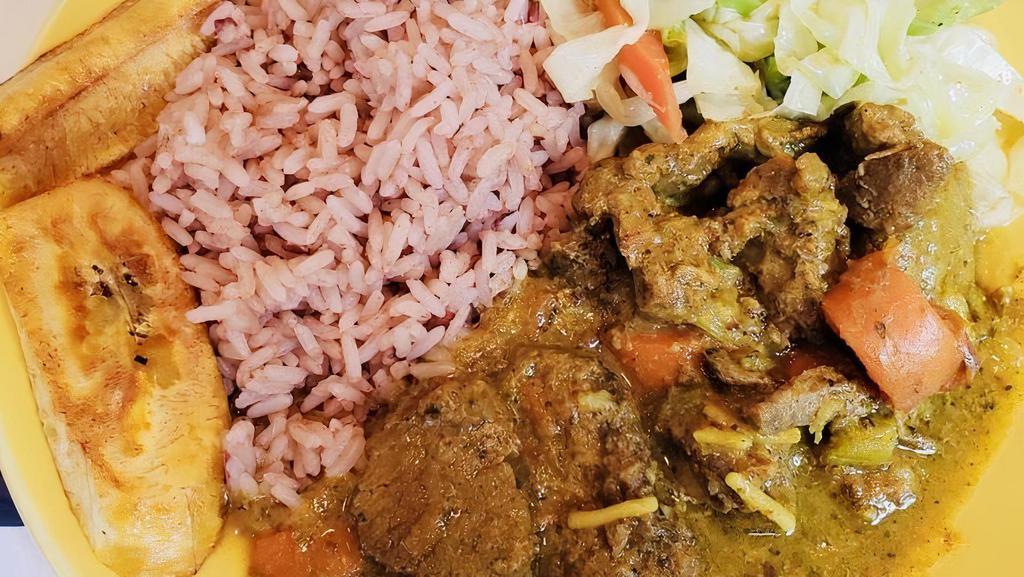 Curry Goat · Chunky pieces of goat slowly simmered in an aromatic blend of garlic, ginger, thyme, onions and hot pepper with a thick and creamy curry sauce taking center stage. Served with rice and beans, fresh vegetables and grilled plantains.