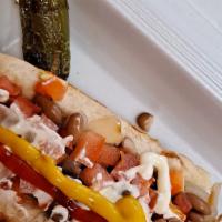 Sonoran Hotdog · Sonoran style hotdog. Weenie wrapped in bacon, diced tomatoes, sautéed onions, whole beans, ...