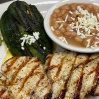 Pollo Asado · Grilled marinated chicken breast. Served with boiled beans, guacamole and a grilled poblano ...