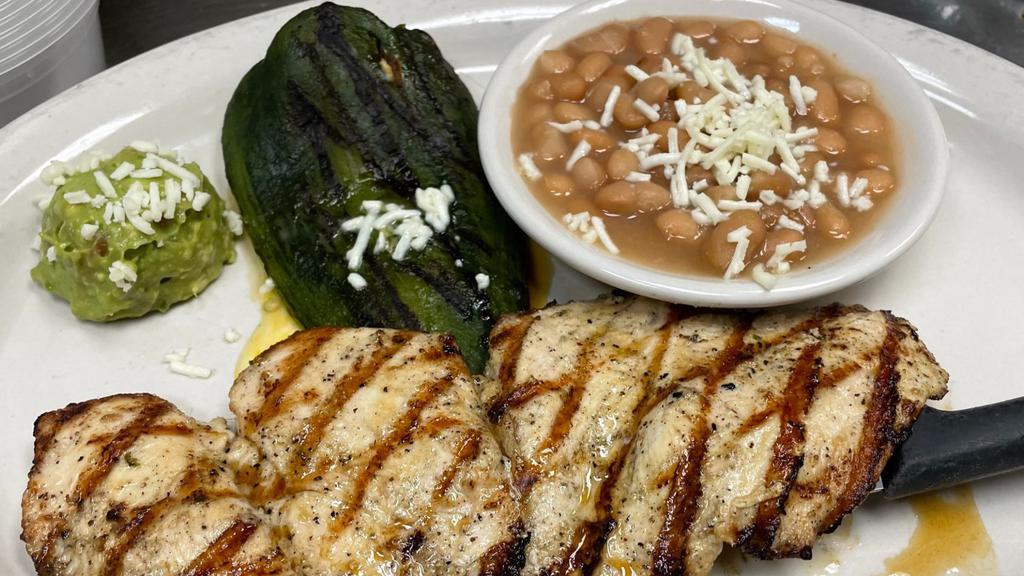 Pollo Asado · Grilled marinated chicken breast. Served with boiled beans, guacamole and a grilled poblano pepper stuffed with cheese.