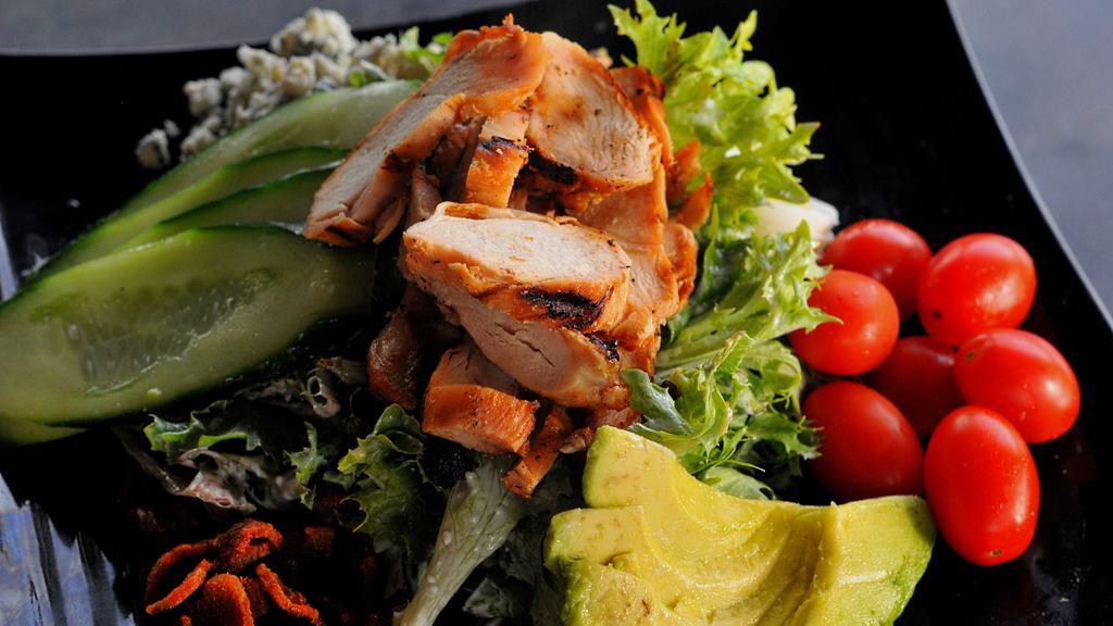 Cobb Salad · Spring mix lettuce topped with grilled chicken, bacon, egg, tomato, avocado, cucumber and blue cheese crumbles. Served with a side of house blue cheese dressing.