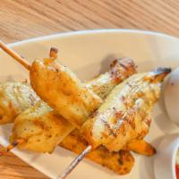 Satay · Marinated chicken on skewers with yellow curry powder, grilled and served with peanut sauce.