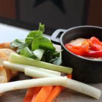 Roasted Red Pepper Hummus · Roasted red pepper hummus served with crispy pita rounds, celery and carrot sticks.