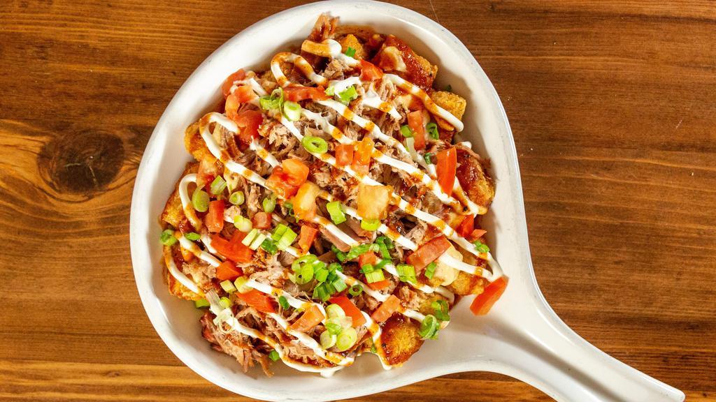 Pork Tot-Chos · Tater tots, pulled pork, cheese sauce, tomatoes, green onions, sour cream & spicy BBQ sauce.