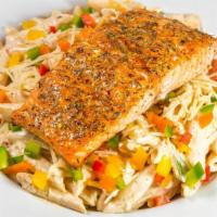 Salmon Rasta Pasta · Penne pasta tossed in a parmesan cream sauce with bell peppers, topped with our grilled jerk...
