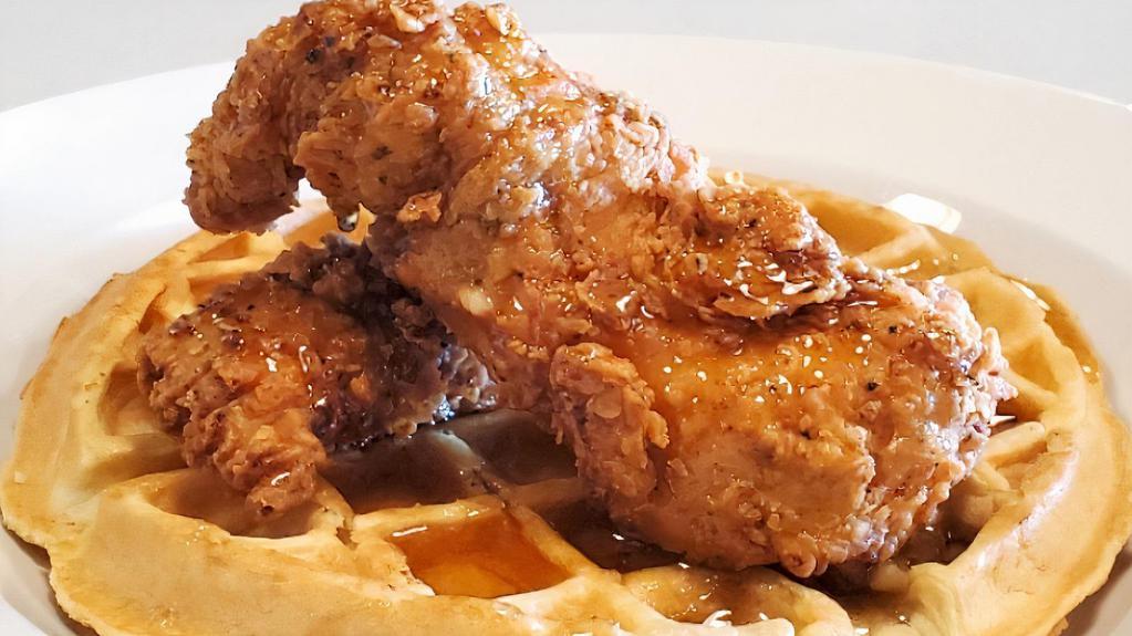 Chicken & Waffles · Two pieces of our hand breaded  buttermilk chicken strips with a fluffy Belgian waffle and syrup. The perfect combo of salty and sweet.