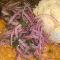 Cordero A La Norteña · Braised lamb in cilantro/ aji amarillo sauce, canario beans, white rice and salsa criolla