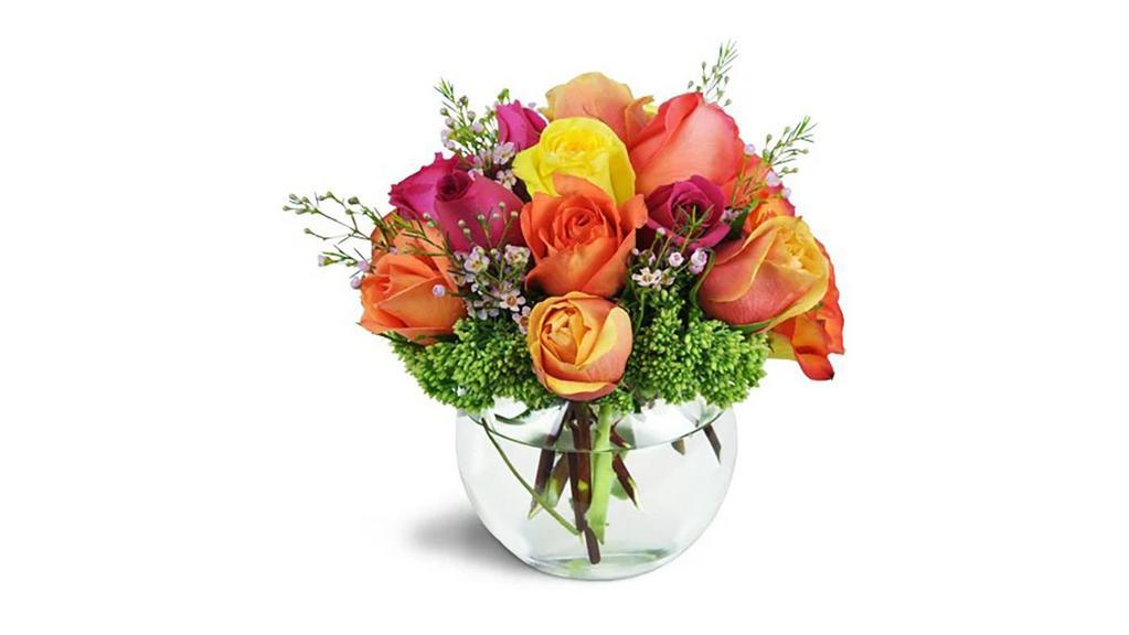 Catch Your Heart™ · She's caught your heart - and you'll catch hers with this stunning, steamy-hot arrangement of vibrant roses! Hot pinks, bright oranges, and cheery yellows make for a fantastic romantic treat!

Over a dozen roses in warm shades of pink, orange, and yellow are arranged with waxflower and sedum in a charming bubble bowl vase.

Approximately 10