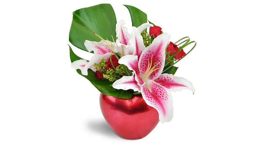 Starry-Eyed Love™ · She'll have stars in her eyes after receiving this stunning gift! Beautiful, large stargazer lilies and delicate deep red spray roses are a simply fantastic treat for a very special day. 

Stargazer lilies and fragrant spray roses are arranged in an adorable red heart-shaped keepsake vase! It's two gifts in one! 

Approximately 9