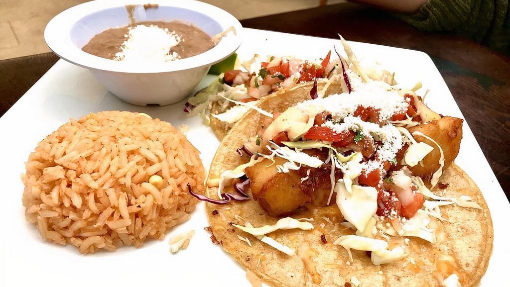 Baja Fish Tacos · Battered white fish fried to perfection topped with cabbage, pico de gallo, sour cream & cheese. Served with rice & beans.