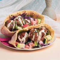 Falafel Hummus Pita Sandwich · Falafel with hummus, shredded cabbage, diced tomato and cucumber, and a tahini drizzle wrapp...