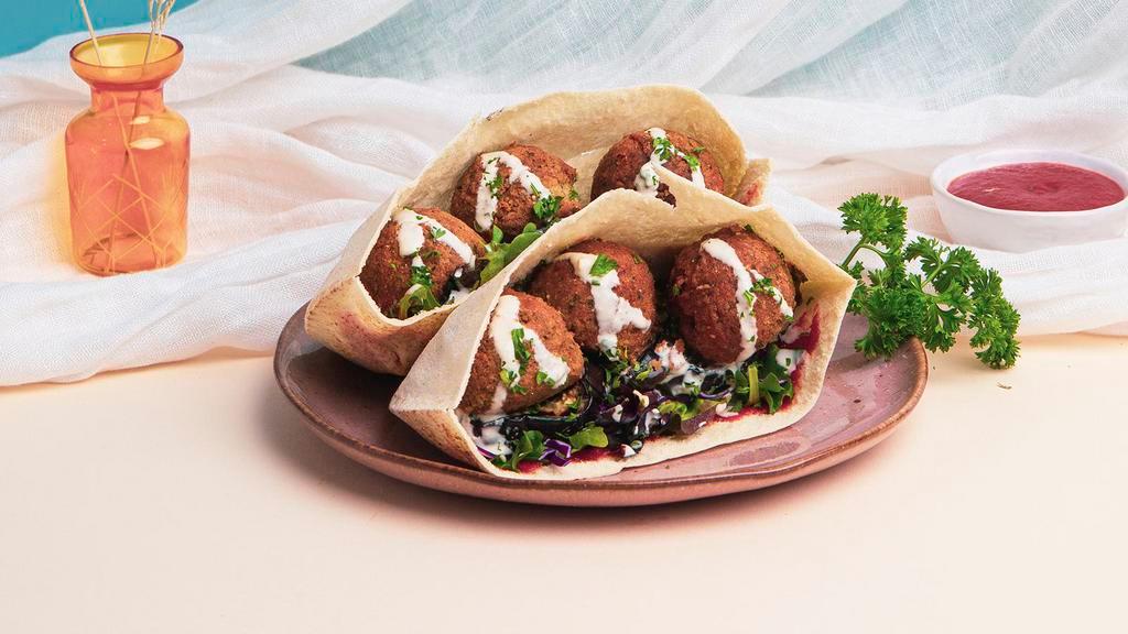 Falafel Eggplant Pita Sandwich · Falafel with grilled eggplant, shredded cabbage, chopped parsley, and red harissa wrapped up in a fresh pita.