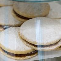 Peruvian Style Alfajores · Two cookies filled with caramel cream and powdered sugar on top.