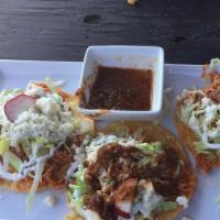 Taquitos De Tinga · Spicy. Crispy rolled corn tortilla shredded chipotle chicken, onions and tomatoes. Topped wi...