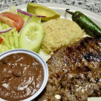 Carne Asada · Marinated grilled steak served with rice, beans and salad.