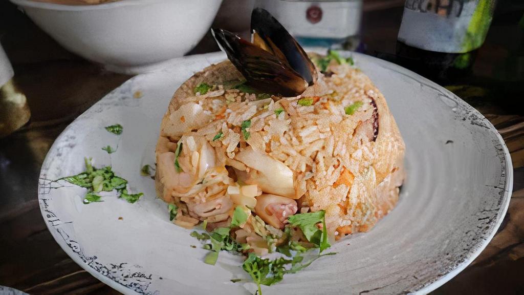 Marinero Rice · Fried rice cooked with shrimp, octopus, fish, and squid, topped with cilantro.